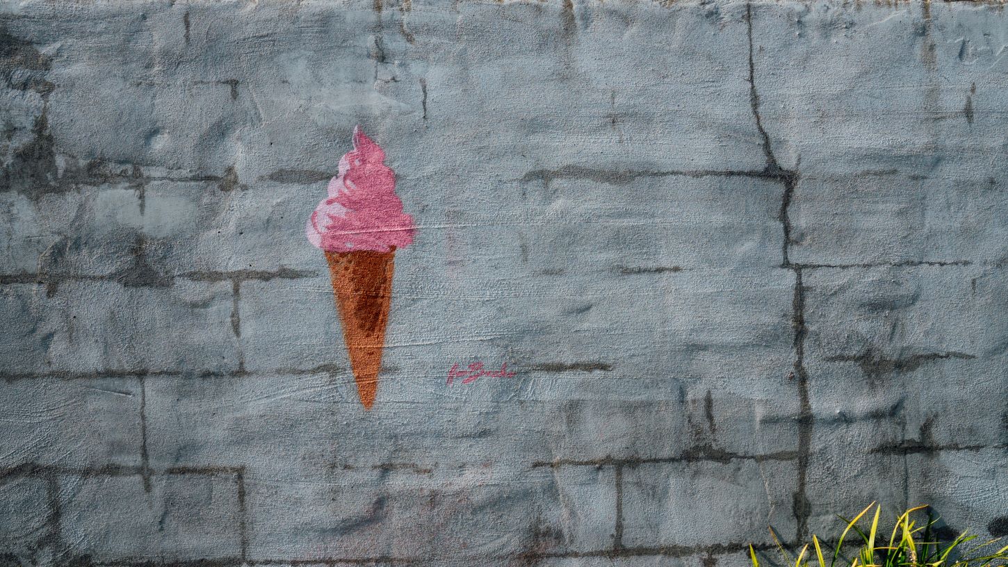 An ice cream cone painted on a grey wall. 